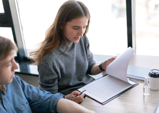 A student reviews a transcript translation with course titles aligned.