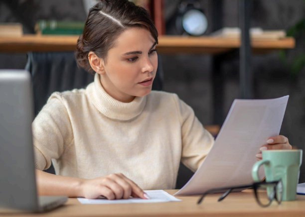 A student checks a translated transcript while Minneapolis Translation Services verifies grades, credits, and course titles.
