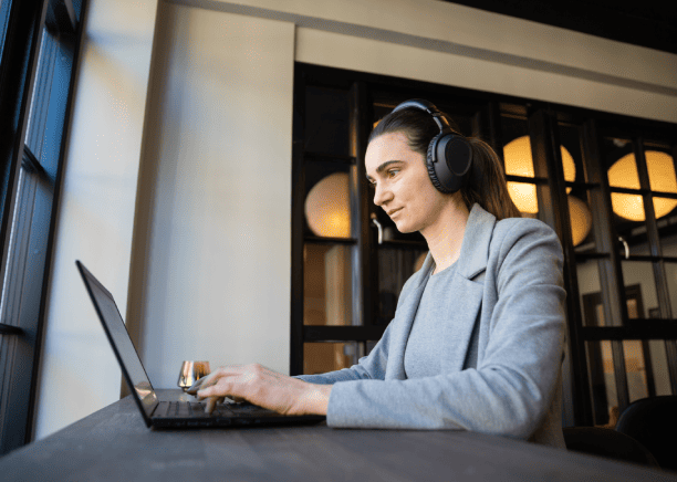 Translator working on a laptop, representing professional audio translation services for various types of recorded files.