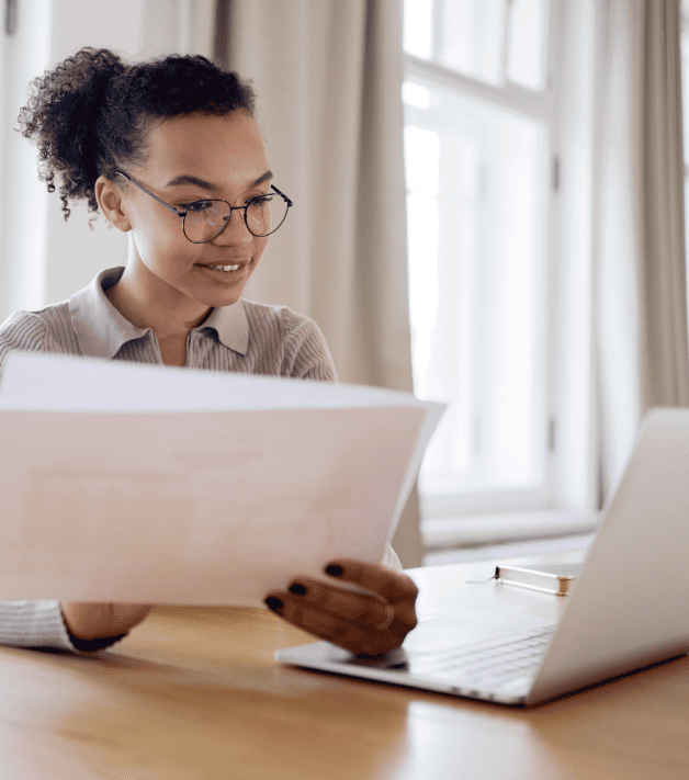 Professional working on a laptop with documents, ensuring high-quality and certified passport translation services.