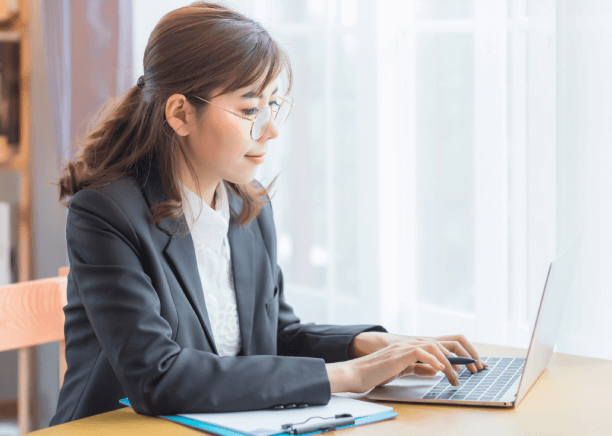 Woman working on her laptop, representing professional translation services in Boston, bridge cultures in a historic city.