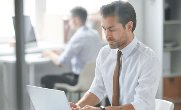 Expert working on a laptop, representing confidential corporate translation services with accuracy.