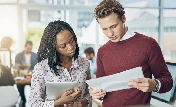 An editor compares bilingual corporate newsletter pages, using Newsletter Translation Services to align tone and branding.