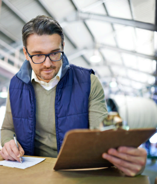 An engineer compares an energy report chart and notes, using Calgary Translation Services for industry-specific wording.