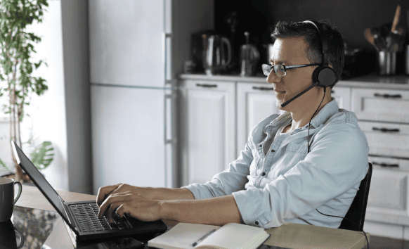 A man working on a laptop represents the rising demand for professional audio translation services in global industries.