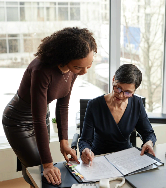 Two linguists build a legal terminology glossary beside an agreement draft, using Agreement Translation Services for clarity.