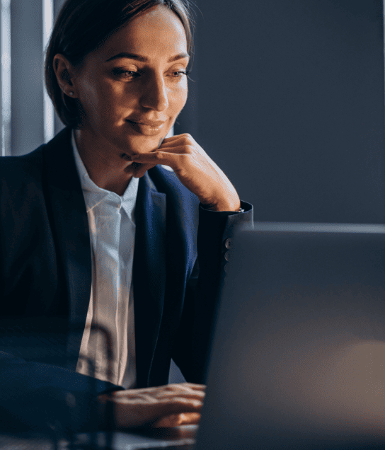 A woman in a suit working with a laptop, providing legal translation services for specific client requirements.
