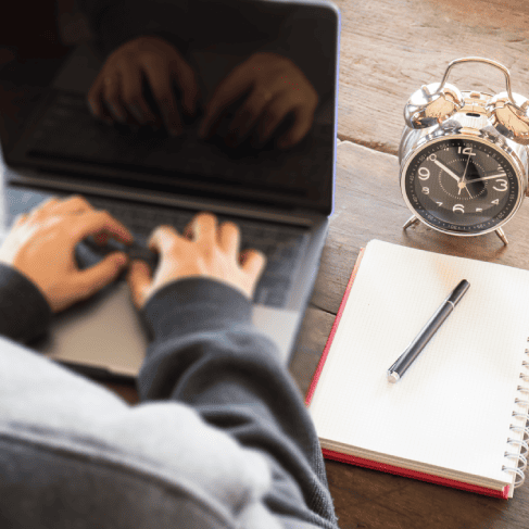 High-angle view of clock and a translator providing fast life science translation services that maintain high quality.