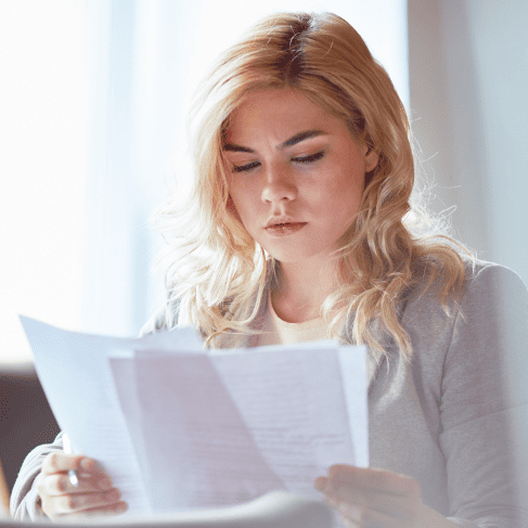 A woman reviewing certificates for certified document translation services in Milwaukee for legal, business purposes.