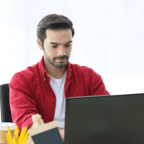 Expert working on a laptop in an office, representing professional and reliable Spanish translation services in Calgary.