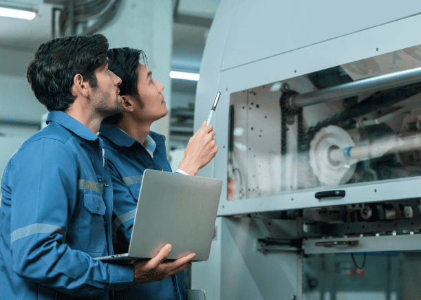 Engineers working on complex machinery, using translated technical manuals for reliable product understanding and execution.