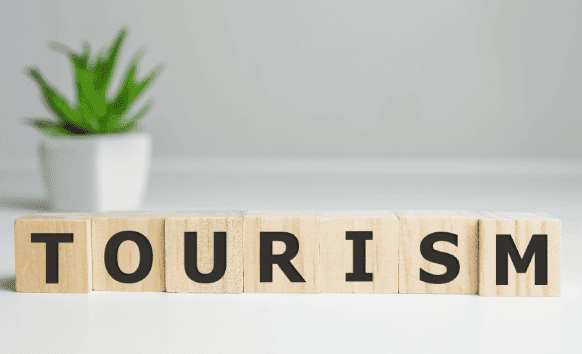 Wooden cubes spelling tourism, symbolizing quality translation services for Charlotte's tourism and industries.