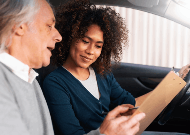 A driver hands a translated license from Driver's License Translation Services to a rental desk agent to avoid delays.