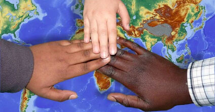 Three hands of people from different races and different skin colors touching at the tips