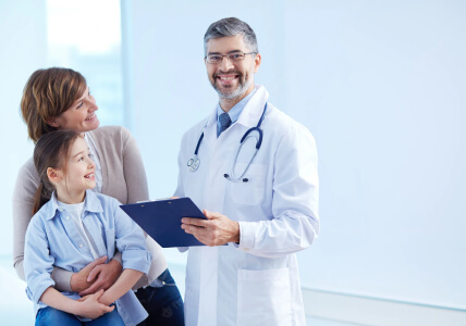 Doctor Smiling while Holding a Clipboard with Patients