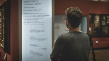 Man viewing a museum notice board, highlighting museum language services designed to cater to an international audience. Man viewing a museum notice board, highlighting museum language services designed to cater to an international audience.