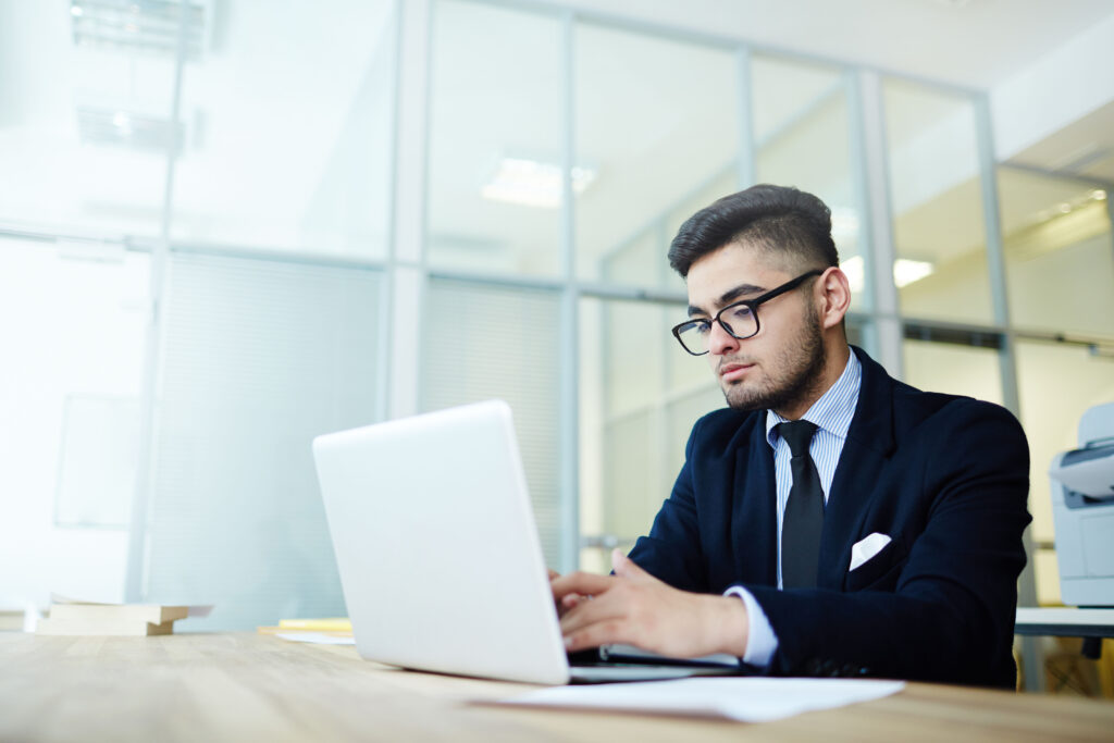 A person diligently working on Certified Spanish Translation services, focused on a computer screen